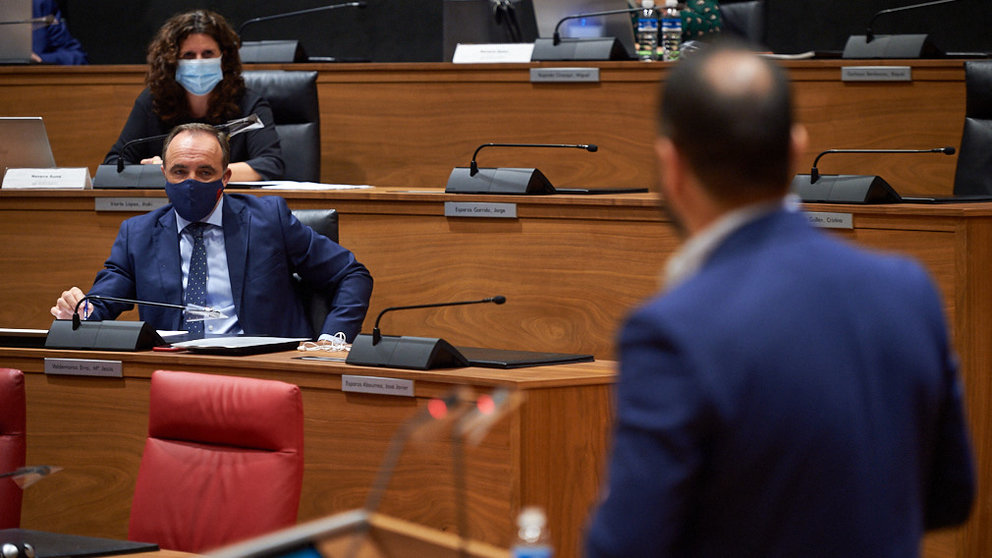 Javier Ezparza (i) observa atentamente al portavoz del PSN, Ramón Alzorriz (i), durante el pleno del parlamento. MIGUEL OSÉS
