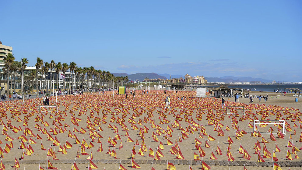 Varias personas visitan la Playa de la Patacona de Alboraya en la que se han colocado un total de 53.000 banderas de España en homenaje a los fallecidos por coronavirus, en Alboraya, Valencia (España). EUROPA PRESS