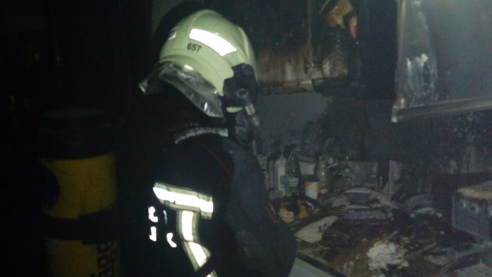 Un bombero trabaja en la extinción de un incendio en una cocina de un piso en la Rochapea. BOMBEROS DE NAVARRA