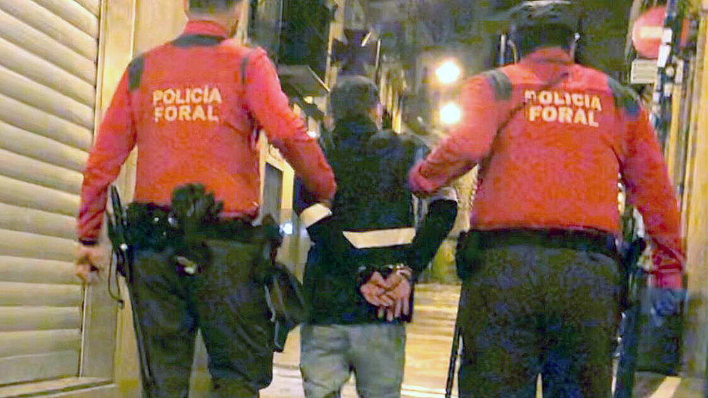 La Policía Foral se lleva detenido a uno de los integrantes de la fiesta en un piso de la calle Mercaderes de Pamplona. POLICÍA FORAL