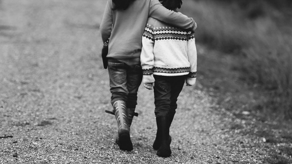 Dos niñas pasean por un camino. ARCHIVO