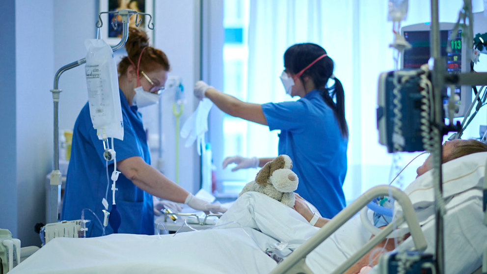 Dos enfermeras atienden a una persona en la UCI mientras sujeta un perro de peluche. PABLO LASAOSA