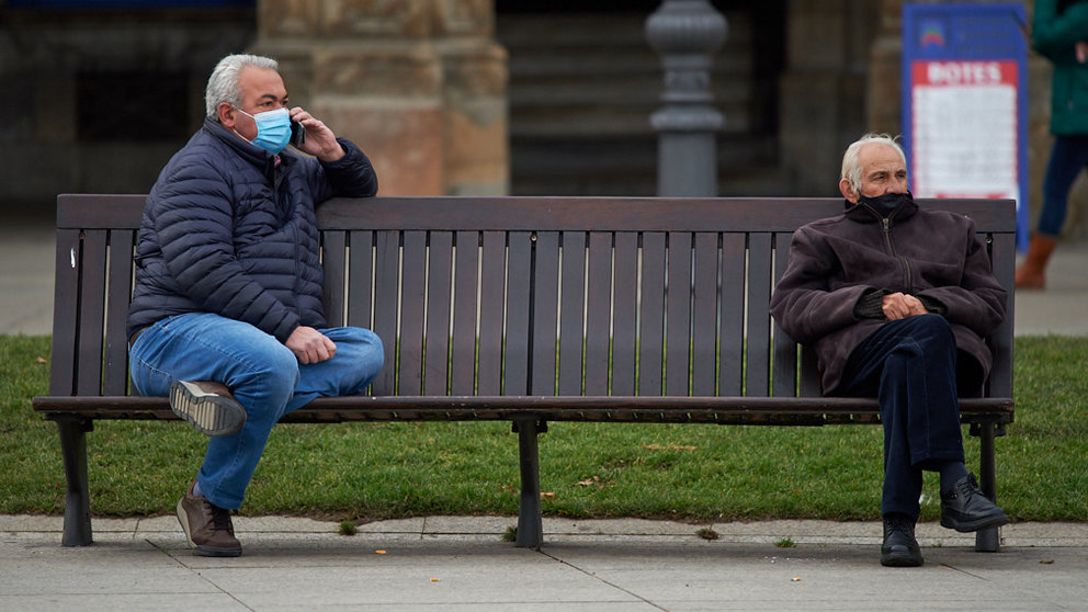 Dos señores sentados en un banco de la Plaza del Castillo durante la pandemia de coronavirus. MIGUEL OSÉS