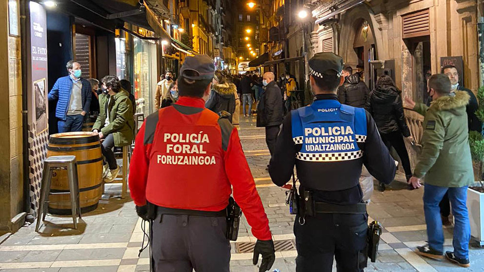 Dos agentes de la Policía Foral y de la Policía Municipal patrullan por las calles del Casco Viejo de Pamplona.