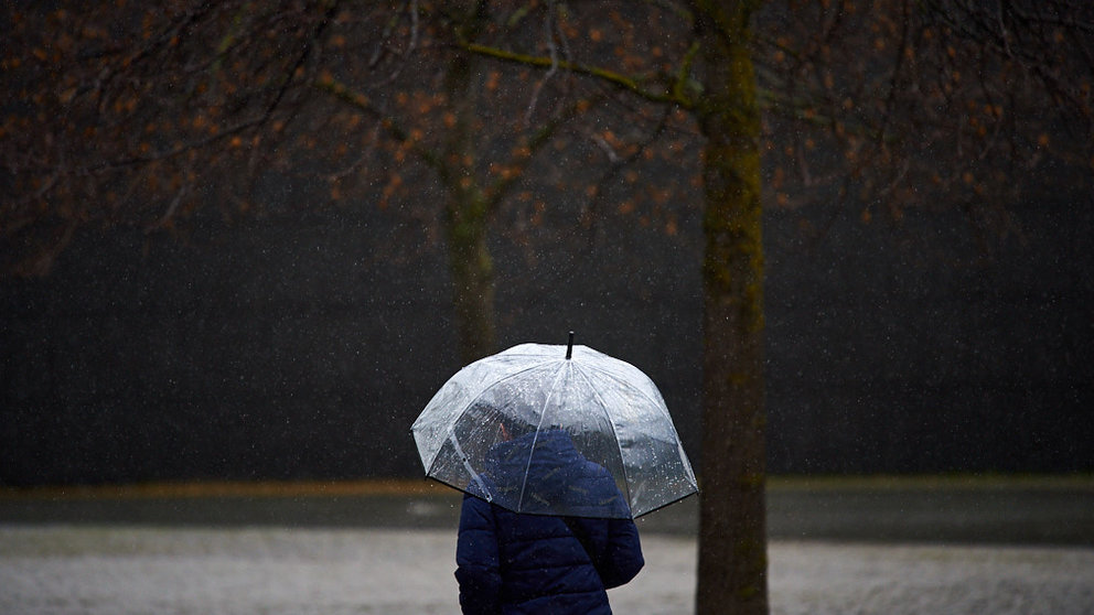 Una mujer con paraguas camina bajo la lluvia por las calles de Pampolona durante la tercera ola del coronavirus en la Comunidad Foral. MIGUEL OSÉS
