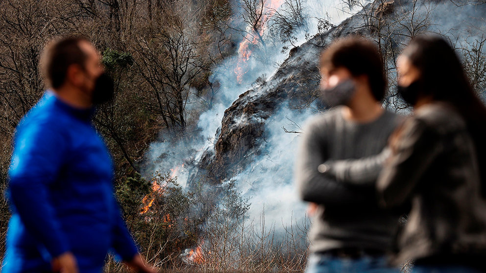 Varias personas observan este domingo en Endarlatsa (Gipuzkoa) un foco del incendio forestal que afecta al norte de Navarra y Gipuzkoa, que actualmente se encuentra "estabilizada" en la parte guipuzcoana, donde los equipos de extinción trabajan en dos "puntos críticos", en Endarlatsa y en una zona próxima a dos bordas de Irun. EFE/Javier Etxezarreta
