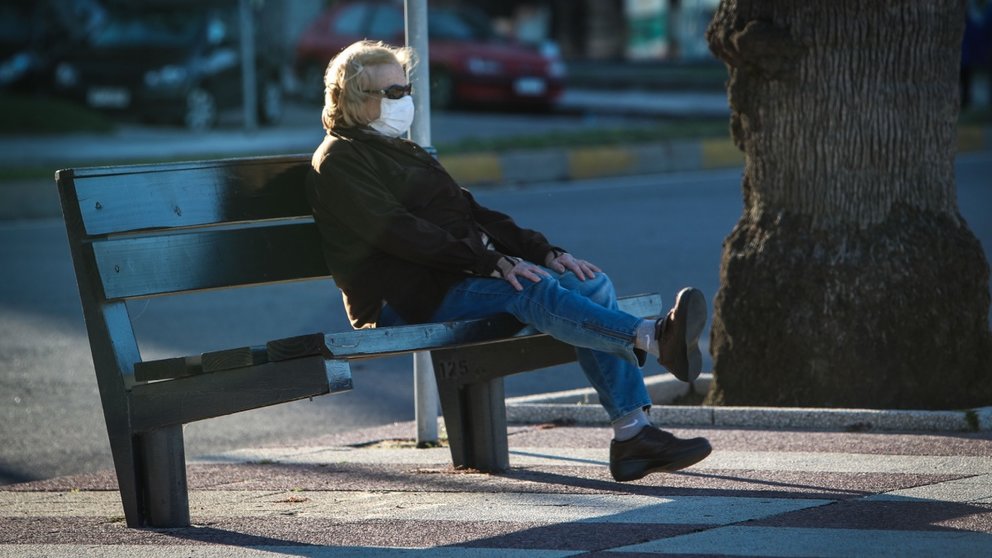 Una mujer descansa sentada en un banco con una mascarilla puesta durante la crisis del coronavirus. EFE/Federico Anfitti