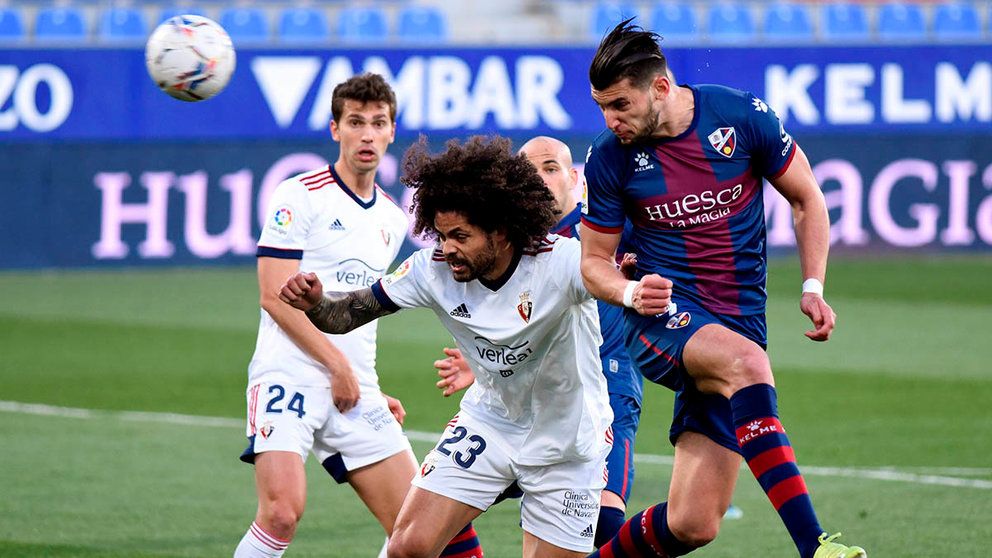 El defensa de Osasuna Aridane Hernández (i) intenta evitar el remate de Rafael Mir, delantero de la SD Huesca, durante el partido de la jornada 28 de Liga en Primera División que se juega hoy sábado en el campo de El Alcoraz. EFE/JAVIER BLASCO