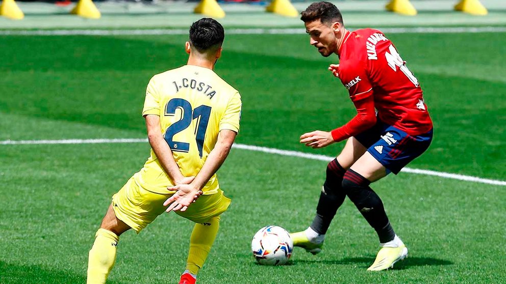 El delantero del Villarreal, Jaume Costa y el delantero del Osasuna Enrique Barja (d) luchan por el balón durante el partido de Liga que disputan en el estadio de la Cerámica. EFE/ Domenech Castelló