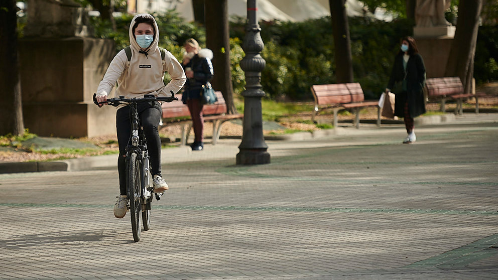 Una persona anda en bicicleta por Pamplona con mascarilla para evitar propagar el coronavirus. PABLO LASAOSA