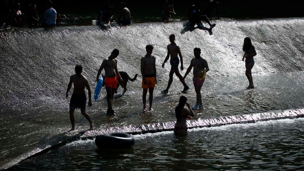 Varias personas aprovechan las altas temperaturas para bañarse en el rio junto al Club Natacion en Pamplona. MEGAN WALLS