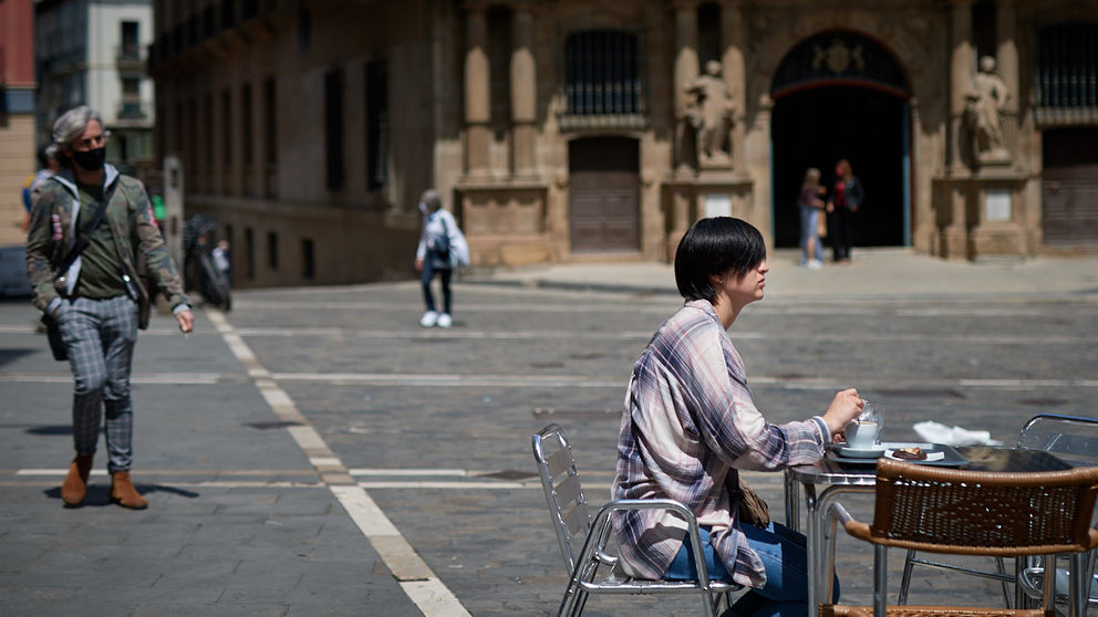 Una mujer se toma un cafe sentada en la Plaza del Ayuntamiento de Pamplona una semana antes de la nueva bajada de restricciones por la pandemia del coronavirus en la Comunidad Foral de Navarra. MIGUEL OSÉS