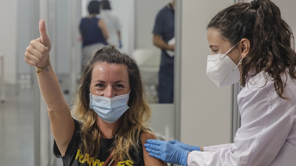 Una joven sonríe y saluda mientras recibe la vacuna contra el Covid-19. EUROPA PRESS