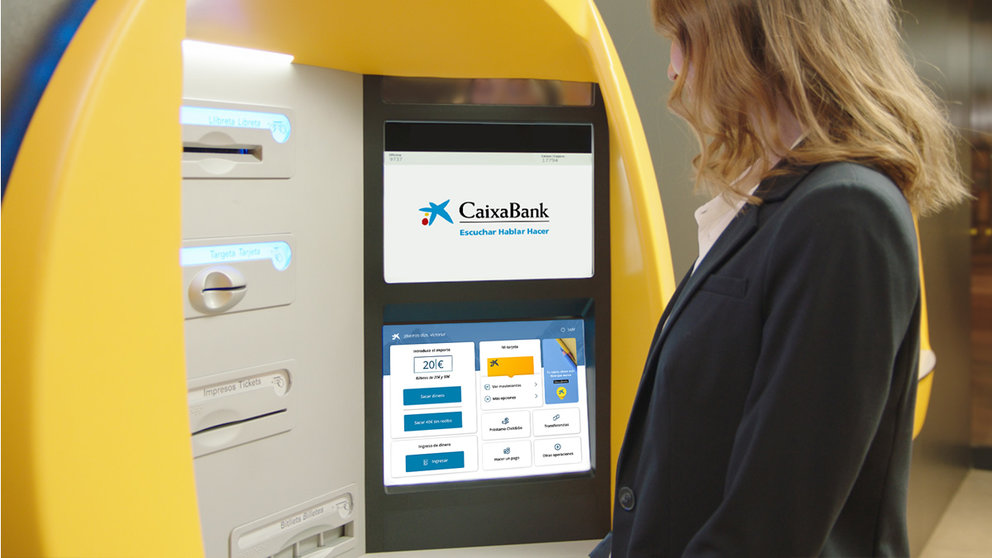 Una persona realiza operaciones en un cajero de CaixaBank. CEDIDA