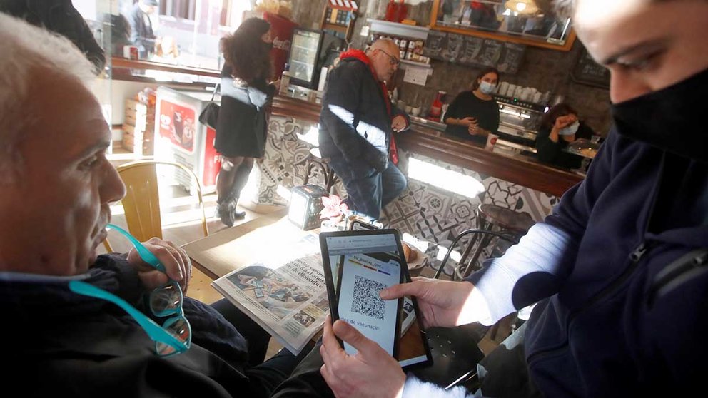 Un camarero escanea el código QR del certificado de vacunación de un cliente en un bar. EFE/Marta Pérez
