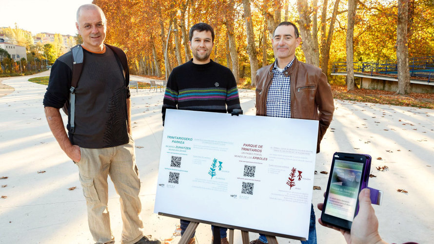 De izq. a dcha. Raúl Escrivá, Julen San Emeterio y Alfredo Pina, con las placas informativas y la aplicación móvil, en el parque de Trinitarios (Pamplona).