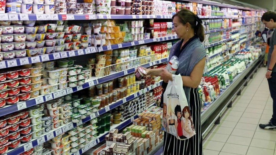 Una mujer mira un producto a la venta en un supermercado. EFE.