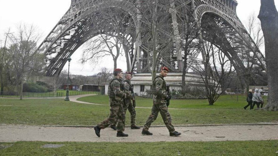 Varios soldados pasean cerca de la Torre Eiffel, en París (Francia). EFE.