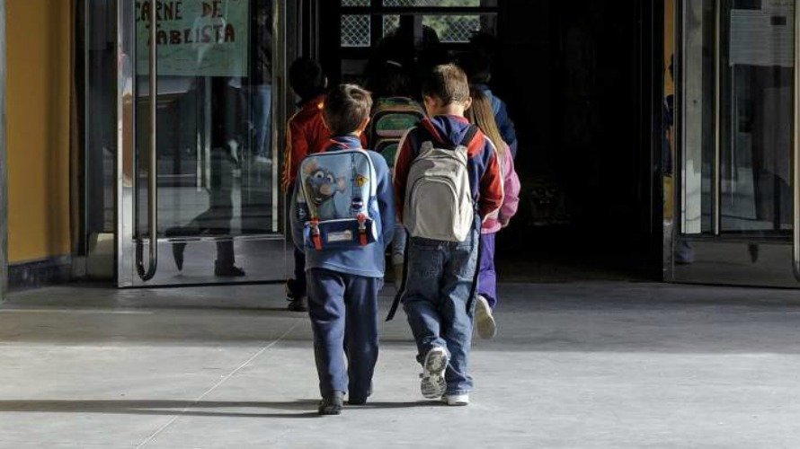 Dos niños entran a la escuela. EFE.