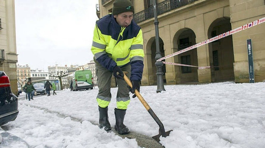 Un operario del Ayuntamiento de Pamplona retira la nieve de la acera para facilitar el paso a los ciudadanos. EFE.
