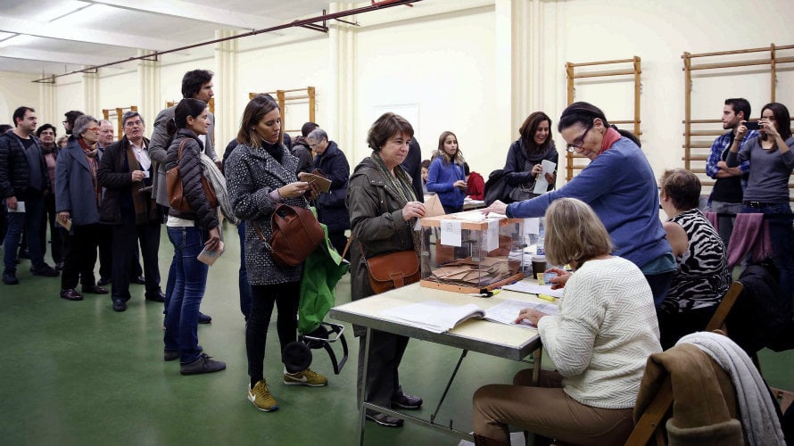 Numerosas personas esperan para votar en la elecciones generales. EFE