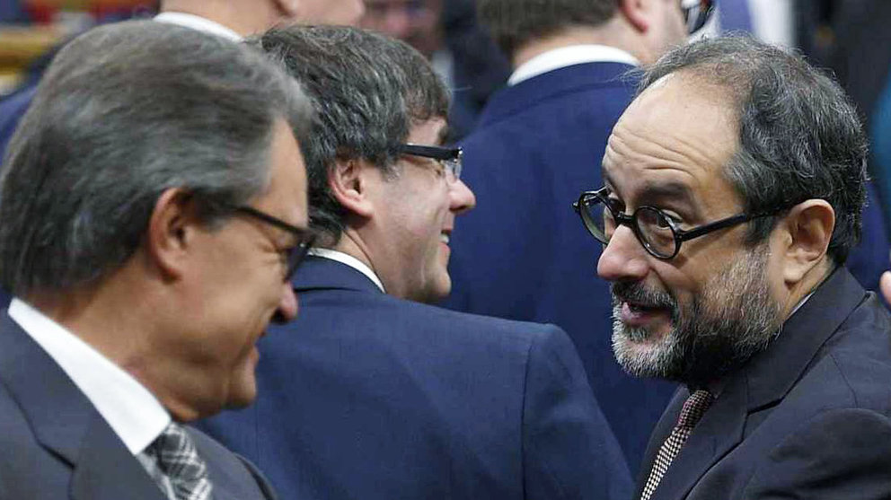 Artur Mas, a la izquierda, saluda al líder de la CUP, Antonio Baños, en el Parlament.