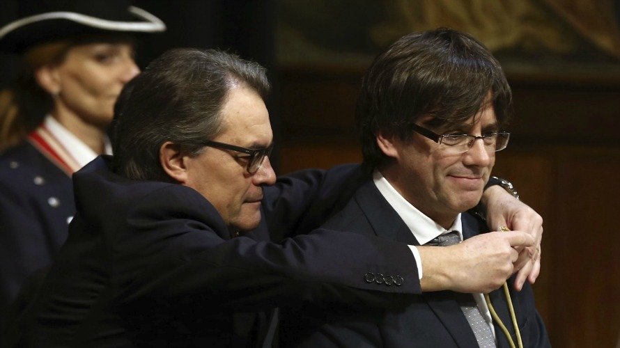 Artur Mas (i), impone la medalla representativa del cargo al nuevo presidente de la Generalitat, Carles Puigdemont, durante su toma de posesión. EFEToni Albir
