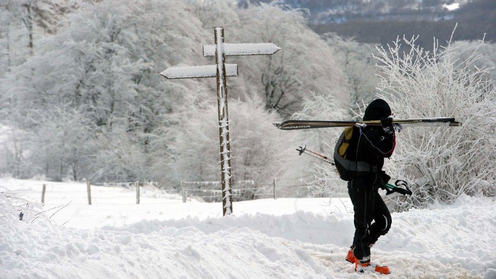 Una persona carga con sus esquís en el Alto de Ibañeta. EFE/Villar López