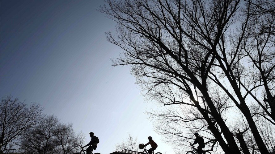 Tres ciclistas, animados por el buen tiempo, pasean por la capital navarra. EFE Jesús Diges.