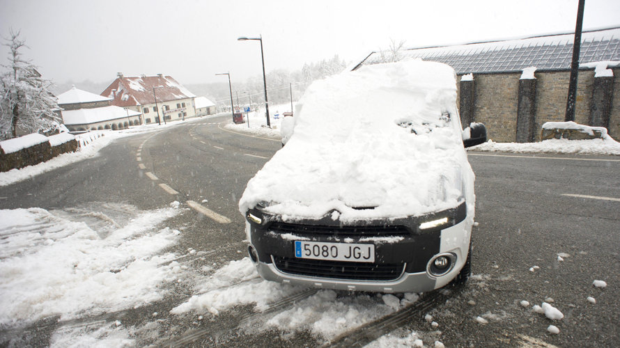 Un coche cubierto de nieve circula por Roncesvalles (Navarra), localidad que hoy ha amanecido nevada debido a la progresiva bajada de la cota de nieve, que ha hecho que durante la noche se movilicen máquinas quitanieves de forma preventiva. EFE/Villar López