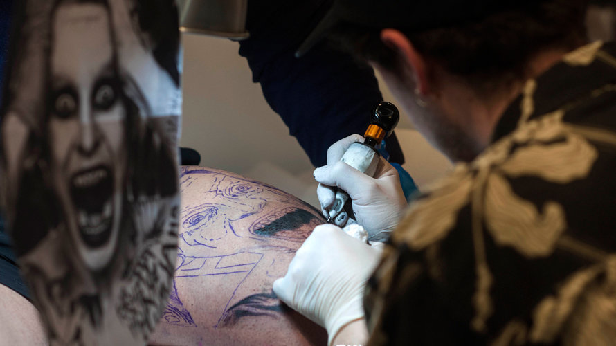 Un tatuador haciendo un tatuaje de un retrato. EFE