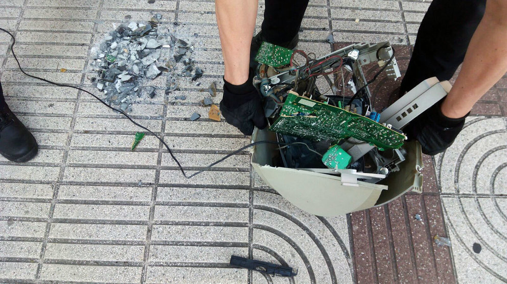 Agentes de la Policía Municipal de Pamplona recogen la pantalla de ordenador lanzada al suelo. PABLO LASAOSA