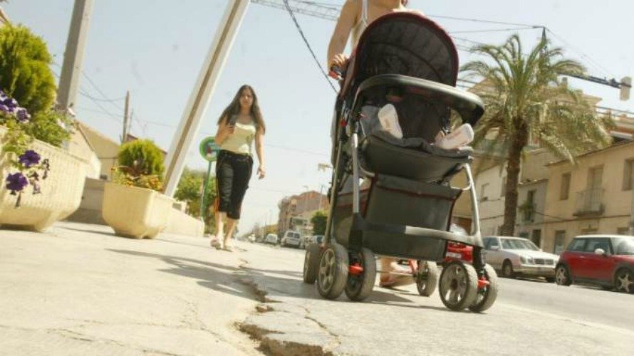 Una mujer paseando con un bebé en un carrito. EFE