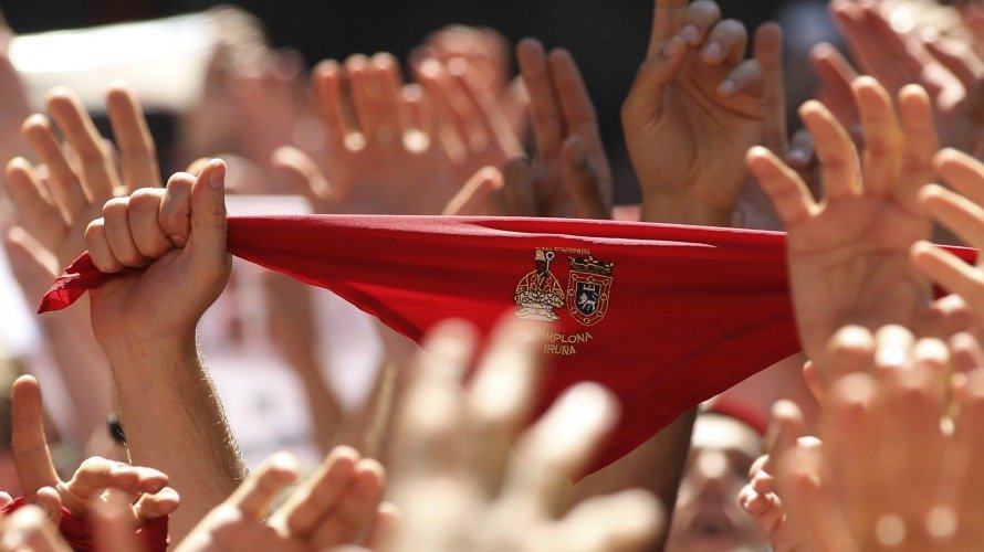 Miles de personas muestran en alto el tradicional pañuelico rojo en la Plaza del Ayuntamiento de Pamplona durante el lanzamiento del Chupinazo. EFE. JAVIER LIZÓN