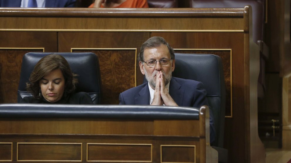 El presidente del Gobierno en funciones, Mariano Rajoy, y la vicepresidenta en funciones, Soraya Sáenz de Santamaría, esta tarde en su escaño durante la segunda sesión del debate de investidura.EFE/Juan Carlos Hidalgo