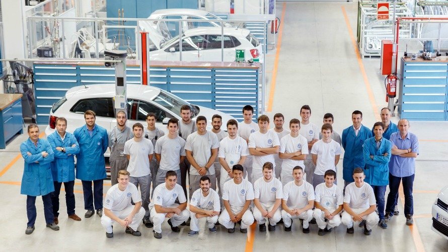 Los participantes en el Programa de Aprendices posan, junto a técnicos y monitores de Volkswagen Academy, en la zona del taller del centro de formación de Volkswagen Navarra.