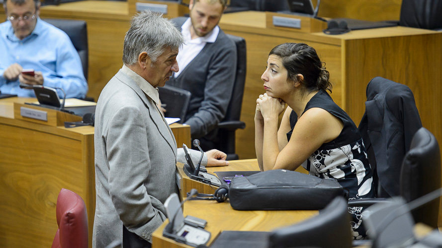 Koldo Martínez (Geroa Bai) y Laura Pérez (Podemos) hablan en el Parlamento de Navarra. PABLO LASAOSA