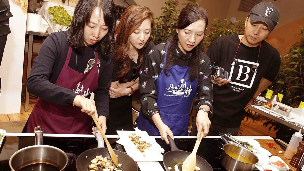 Dos de las finalistas del programa The Real Master Chef del canal público chino Cici Shi (2d) y Sunny Qiu (i), acompañadas por celebridades de su país, en las cocinas de las Bodegas Otazu, en Navarra. EFE/Ivan Aguinaga