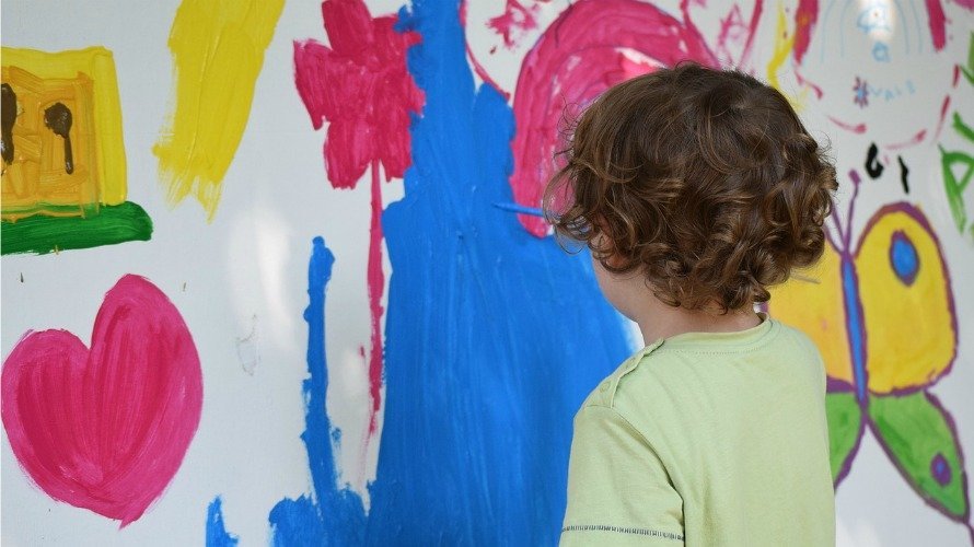 Un niño pintando un paisaje.