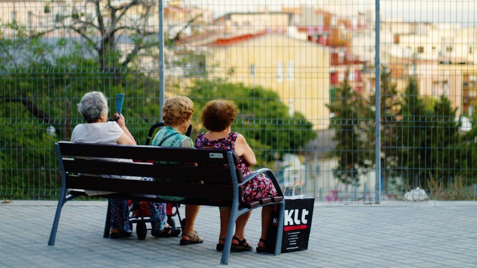 Un grupo de mujeres de edad avanzada hablan sentadas en un banco ARCHIVO