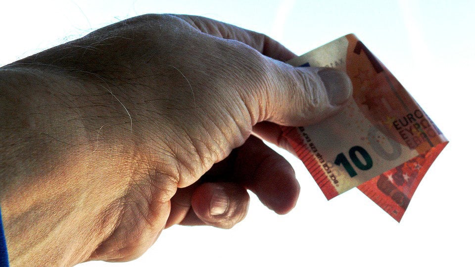 Imagen de un hombre portando un billete para realizar un pago ARCHIVO