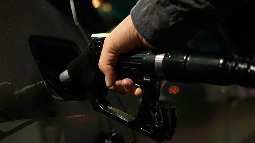 Un hombre llena de gasolina el tanque de su vehículo en una gasolinera.