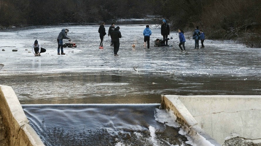 Tiempo. Un grupo de jóvenes juegan al balón sobre la superficie helada del Río Esca a su paso por la localidad navarra de Burgui.  EFE. Jesús Diges
