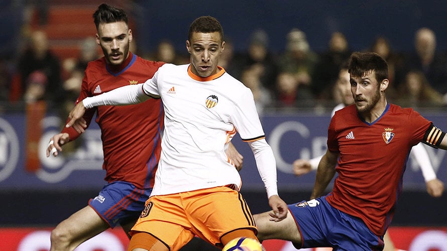 El delantero del Valencia, Rodrigo, se dispone a golpear el balón ante los jugadores de Osasuna, Unai García y Oier Sanjurjo. EFE/Jesús Diges.