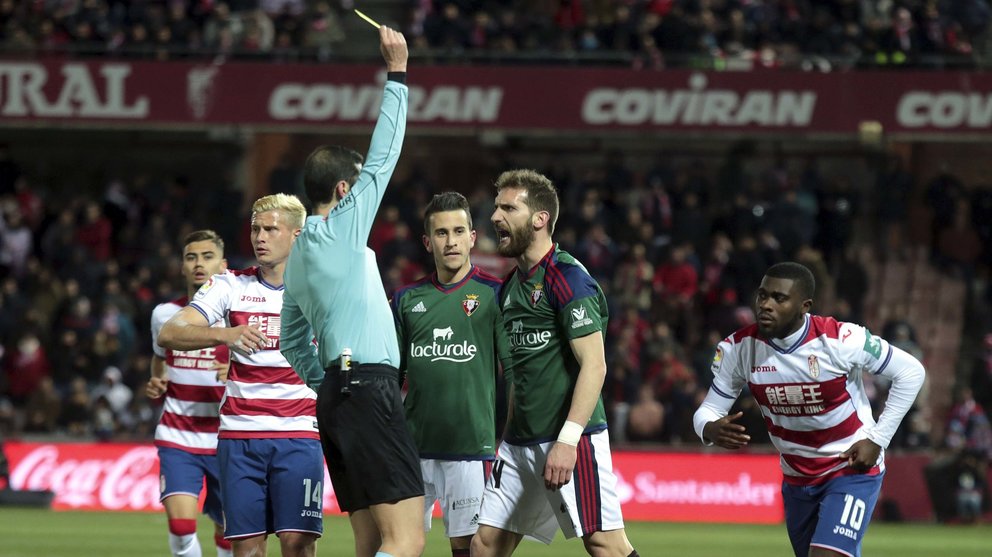 El árbitro saca la tarjeta amarilla al centrocampista del Osasuna Fausto Tienza durante el partido de la decimoctava jornada de Liga que disputan en el estadio Nuevo Los Cármenes. EFE/Pepe Torres