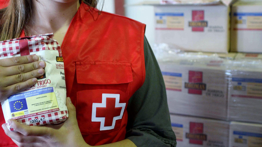 Una voluntaria de Cruz Roja sostiene un alimento en la mano. CEDIDA