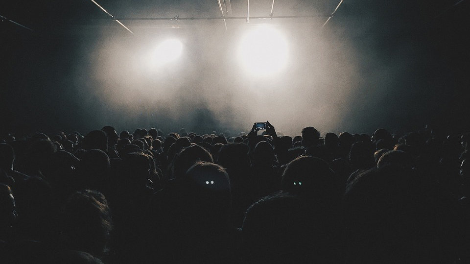 Imagen de varioa jóvenes en una discoteca grabando con sus teléfonos móviles a la espera de que empiece un espectáculo en el escenario ARCHIVO