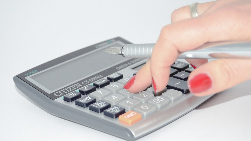 Una mujer utilizando una calculadora.