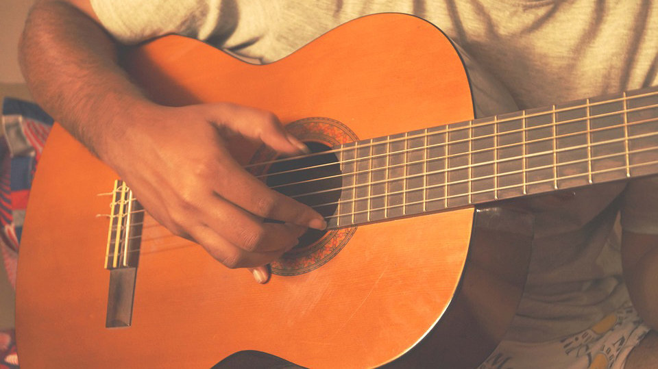 Un hombre tocando una guitarra española.