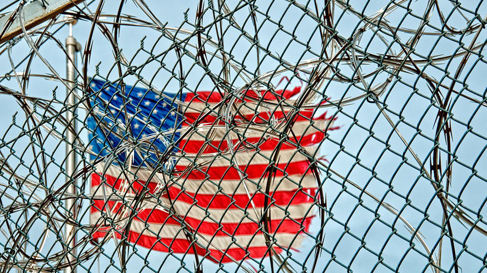 Imagen de una bandera de Estados Unidos ondeando tras el perímetro de seguridad de una prisión ARCHIVO